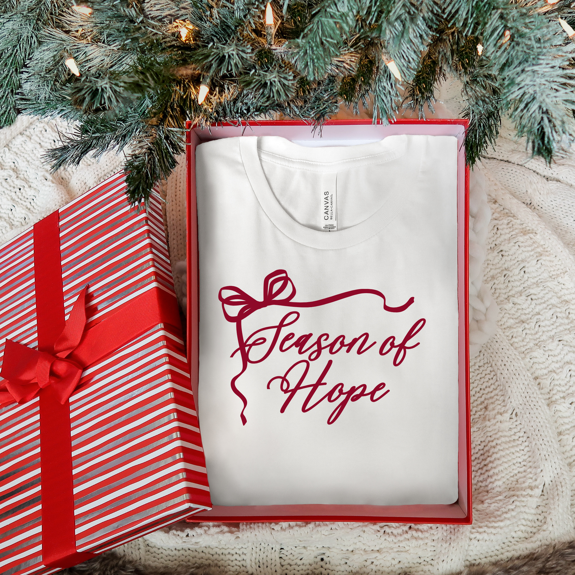 White t-shirt with 'Season of Hope' text under a Christmas tree with a gift box.