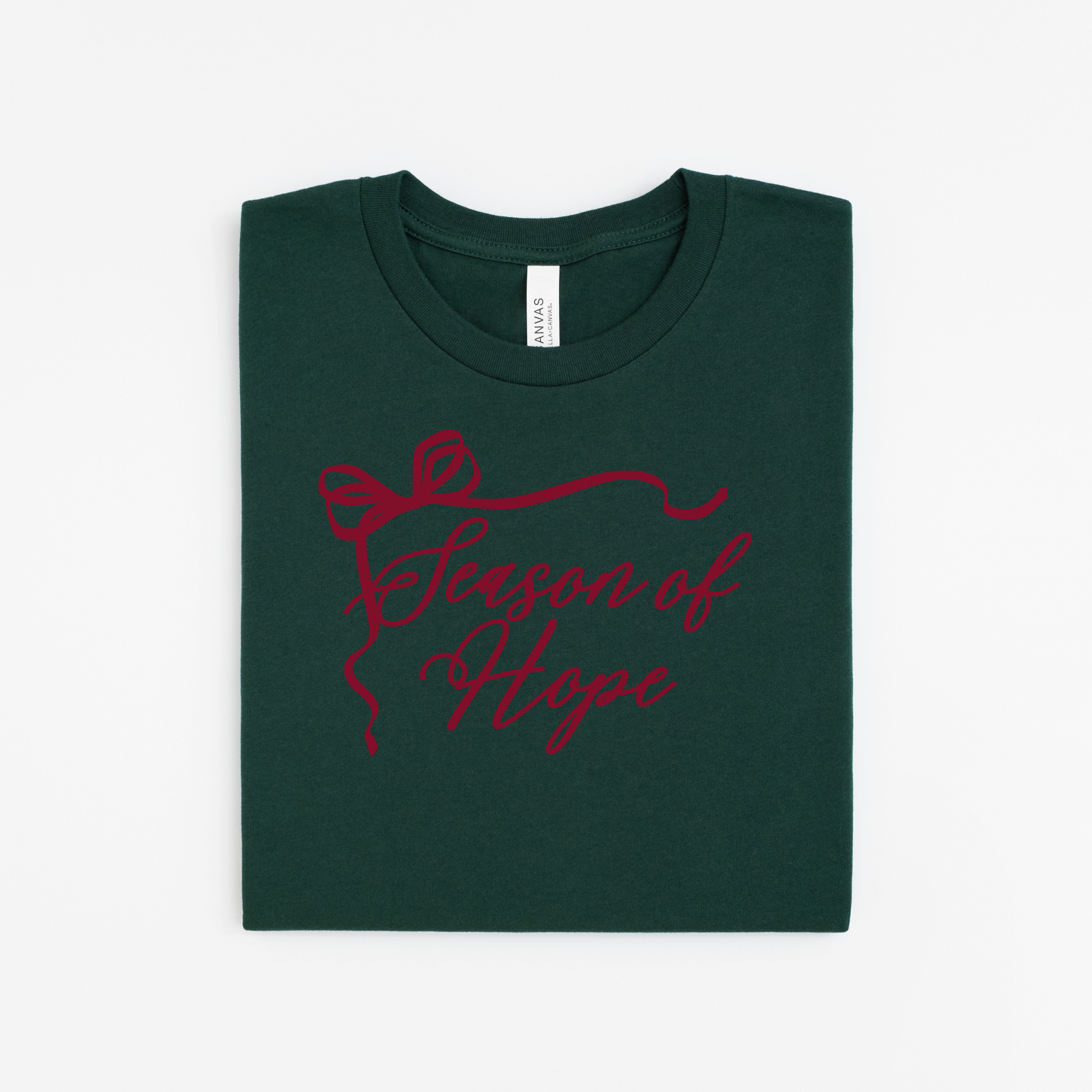 Green t-shirt with red text and bow design on a white background