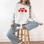 light grey sweater featuring six hand-drawn red poppies representing 1 in 6 infertility awareness.