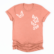 a sunset orange tee with six white butterflies symbolizing the 1 in 6 infertility statistic
