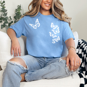 Woman wearing a carolina blue tshirt with six white butterflies symbolizing the 1 in 6 infertility statistic.