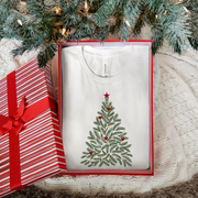 White t-shirt with Christmas tree design in a box under a decorated tree